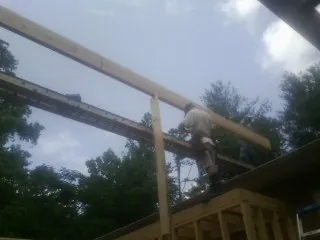 Carpenter setting a ridge beam over a new addition frame — Ice Dam Removal by Roofing Brothers in Trail